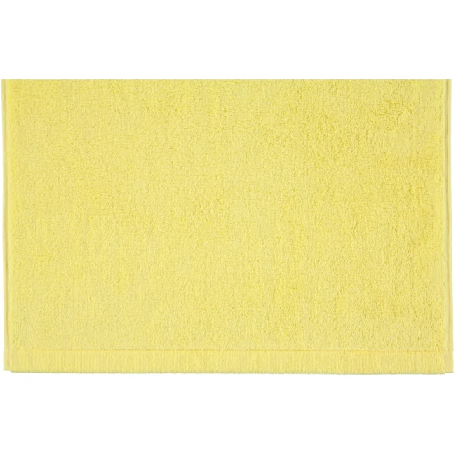 Ręcznik bawełniany 70x140 cm w intensywnym cytrynowym kolorze, prezentowany w pozycji leżącej na jednolitym tle. Tekstura materiału jest miękka i puszysta, co zapewnia komfort użytkowania. Dolna krawędź ozdobiona jest delikatnym wykończeniem.
