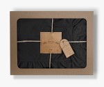 Pościel bawełniana z falbanką 160x200 Stonewashed Exclusive w kolorze czarnym, zapakowana w pudełko z tektury, z widocznym logo LIMASSO HOME CONCEPT.