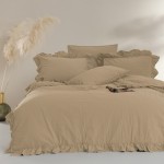 Komplet poszewek bawełnianych 2x40x40 cm w kolorze beżowym, z falbanką. Poszewki leżą na łóżku, otoczone dekoracyjną rośliną. Materiał jest miękki, z delikatną teksturą, tworząc elegancki wygląd.