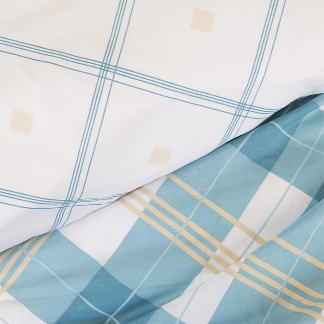 Pościel bawełniana 220x200 w kolorze białym i błękitnym, z wzorem kraty. Widoczne linie w odcieniu błękitu i kremu. Produkt leży na płasko, ukazując detale materiału oraz wyrazisty wzór. Tło jest jasne, co podkreśla kolory pościeli.