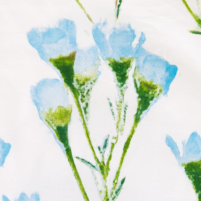 Pościel bawełniana 220x200 Cottonlove w białym kolorze z delikatnym wzorem kwiatów w odcieniach błękitu i zieleni. Widok z przodu, ukazuje fakturę tkaniny oraz detale wzoru kwiatowego. Produkt leży płasko na jednolitym tle.