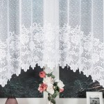 Firana żakardowa w kolorze białym o wymiarach 300x160 cm, z delikatnym wzorem w kropki oraz haftowanymi kwiatami na dolnej krawędzi. Ujęcie frontalne, firana wisząca, w tle widoczny bukiet różowych kwiatów i ciemne tło.