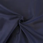 Pościel satyna bawełniana 220x200 w kolorze ciemnego granatu, ukazująca gładką, błyszczącą powierzchnię materiału. Złożona w formie, z widocznymi zagięciami, na jednolitym tle, co podkreśla jej charakterystyczną fakturę i kolor.