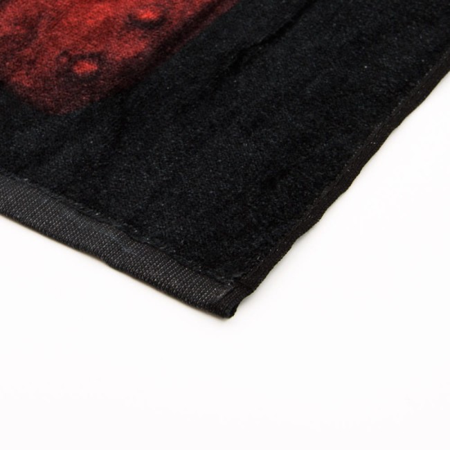 Ręcznik bawełniany dla dzieci 70x140 cm, w kolorze czarnym, z motywem Hedwigi z serii Harry Potter. Frotte, miękki materiał, wykończenie z czarną lamówką, idealny do codziennego użytku. Zbliżenie na krawędź ręcznika, pokazujące teksturę.
