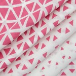 Pościel bawełniana 200x220 Cottonlove Exclusive Milano w kolorze różowym z geometrycznym wzorem białych trójkątów. Materiał gładki, złożony, ukazujący fakturę tkaniny. Zdjęcie wykonane z bliska, w układzie leżącym.