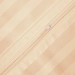 Beżowa pościel bambusowa satyna bawełniana 140x200 w delikatne paski. Widok w zbliżeniu, na widocznym zamku błyskawicznym na poszewce. Gładka faktura materiału, idealna do efektywnego ścielenia łóżka.