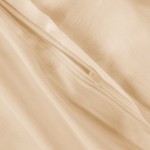 Pościel bawełniana w jasnym beżu, widoczny zamek błyskawiczny na krawędzi. Tkanina o gładkiej fakturze, odzwierciedlająca elegancję. Ujęcie z bliska, skupione na detalu zamka, podkreślające funkcjonalność.
