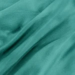 Pościel satyna bawełniana 220x200 w kolorze ciemnego turkusu, leżąca na płasko, ukazująca gładką i jednocześnie lekko błyszczącą fakturę materiału. Widoczne załamania tkaniny, podkreślające jej miękkość.