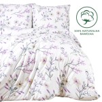 Pościel bawełniana 220x200 w wiosenne kwiaty w odcieniach różu i fioletu. Złożona w układzie na łóżku, z widocznymi poduszkami. Wzór przedstawia delikatne motywy roślinne na białym tle. W prawym dolnym rogu znajduje się oznaczenie 100% naturalna bawełna.
