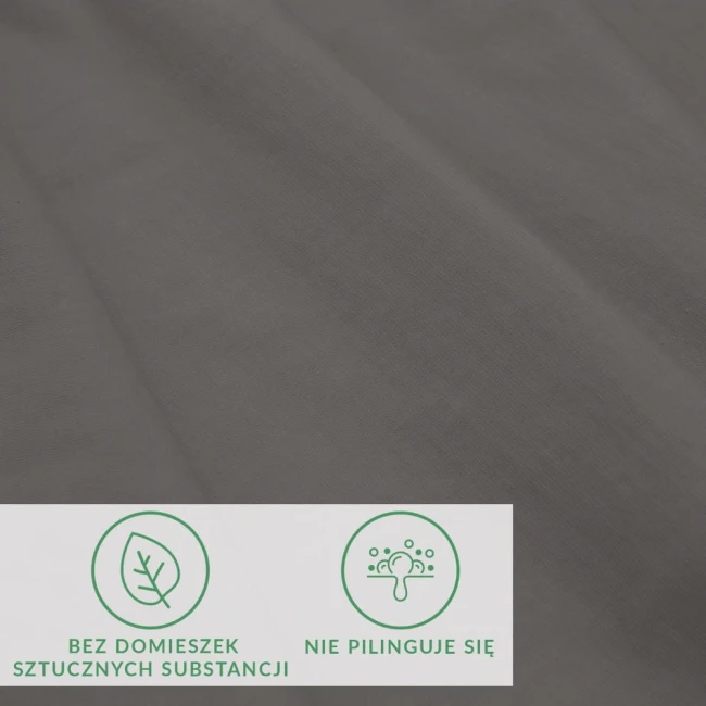 Prześcieradło jersey z elastanem w kolorze antracytowym, leżące na powierzchni. Materiał gładki, elastyczny. Widoczne ikony informujące o braku domieszek sztucznych substancji oraz o właściwości niepilingującej.