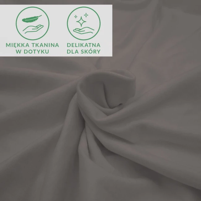 Prześcieradło jersey z elastanem w kolorze antracytowym, leżące na powierzchni, o gładkiej, matowej strukturze. W centrum widoczne ikony informujące o miękkości tkaniny i jej delikatności dla skóry. Produkt przeznaczony do łóżka o wymiarach 180x200.