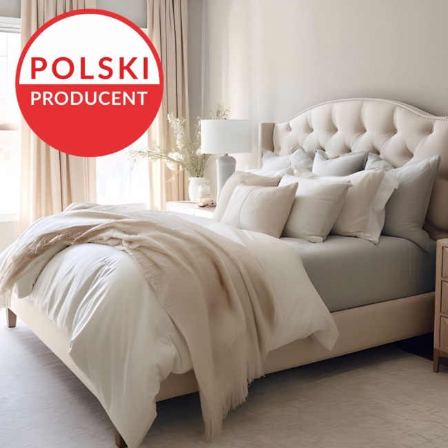 Prześcieradło jersey z elastanem z gumką w kolorze czarnym, rozmiar 200x220, leży na łóżku z jasnym zagłówkiem. W tle widoczne są zasłony i lampka, całość w neutralnej kolorystyce.