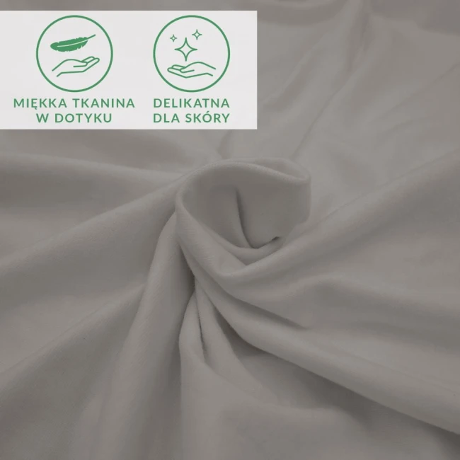 Prześcieradło jersey z elastanem, kolor popiel, rozłożone na jasnej powierzchni. Widać gładką, matową fakturę materiału, który jest elastyczny i miękki w dotyku. Widoczne ikony wskazujące na delikatność tkaniny dla skóry.