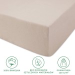 Prześcieradło jersey z gumką 90x200 w kolorze beżowym, wykonane w 100% z bawełny. Zbliżenie na gładką strukturę materiału oraz gumkę, która umożliwia łatwe zakładanie na materac. Gramatura 130 g/m². Bez sztucznych domieszek.