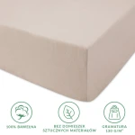Prześcieradło jersey z gumką w kolorze beżowym, rozmiar 120x200 cm, wykonane w 100% z bawełny o gramaturze 130 g/m². Złożone, widok z boku, z wykorzystaniem materiału bez domieszek sztucznych, przyjemna, teksturowana powierzchnia.