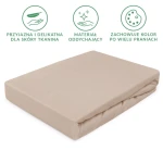 Prześcieradło jersey z gumką 120x200 w kolorze beżowym, leżące na białym tle. Tkanina o gładkiej fakturze, elastyczna, przystosowana do materaca. Widoczne etykiety informacyjne o właściwościach materiału. Brak dekoracji.