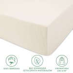 Prześcieradło jersey z gumką w kolorze ecru, wykonane z 100% bawełny. Widoczne jest w ułożeniu leżącym, z wyraźnie zaznaczoną fakturą dzianiny, która jest elastyczna.