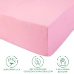 Prześcieradło jersey z gumką w kolorze jasnego różu, wykonane w 100% z bawełny. Złożone, ukazuje bok produktu z fakturą materiału. Widoczne ikony informacyjne o gramaturze 130 g/m² oraz braku domieszek sztucznych materiałów.