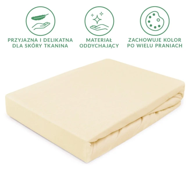 Prześcieradło jersey z gumką w kolorze kremowym, leżące na białym tle. Wyraźny materiał, miękki i elastyczny, idealny do materaca 80x160 cm. Zawiera gumkę do mocowania. Brak dodatkowych wzorów czy napisów.