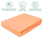 Prześcieradło jersey z gumką 140x200 w kolorze łosoś, leżące na białym tle. Wykonane z oddychającego materiału, zapewniającego wygodę. Z delikatną teksturą i elastyczną gumką. Widoczne informacje o trwałości koloru po wielu praniach.