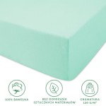 Prześcieradło jersey z gumką w kolorze morskim, o wymiarach 140x200 cm, wykonane w 100% z bawełny. Złożone, pokazane z boku, z czytelnymi ikonami informującymi o gramaturze 130 g/m² oraz braku domieszek sztucznych materiałów.