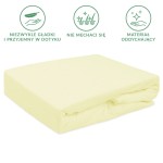Prześcieradło frotte z gumką 90x200 w kolorze kremowym, leżące na boku, z wyraźnie widoczną fakturą materiału. Prezentuje się w prostym otoczeniu, na jednolitym tle, bez zbędnych detali. Dobrze dopasowuje się do materaca, co podkreśla jego użytkowość.