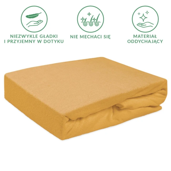 Prześcieradło frotte z gumką w kolorze musztardowym o wymiarach 120x200 cm. Produkt leży na jednolitym tle, wykończony gładką fakturą. Widoczny kształt kremu pasujący do standardowego materaca, z gumką na brzegu, zapewniającą łatwe dopasowanie.
