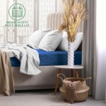 Prześcieradło frotte z gumką 160x200 w kolorze chaber leży na łóżku z jasnoszarym zagłówkiem. Z przodu widoczne są także białe poduszki i lekko rozłożona szara narzuta.