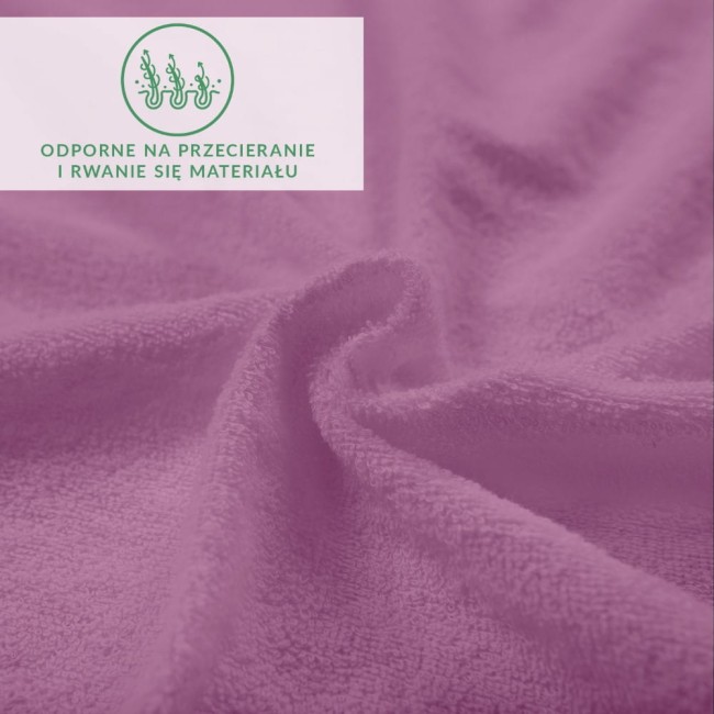 Prześcieradło frotte z gumką w jasnym fioletowym kolorze, wytrzymałe na przetarcia, z miękką, teksturowaną powierzchnią. Ułożone na płaskiej powierzchni, z widocznymi fałdami, pokazujące elastyczność materiału.