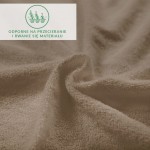 Prześcieradło frotte w kolorze kakao, z miękką i teksturowaną powierzchnią. Zdjęcie zbliżeniowe ukazuje delikatne fałdy materiału, co podkreśla jego elastyczność. Ekologiczny symbol bezpieczeństwa widoczny na tle.