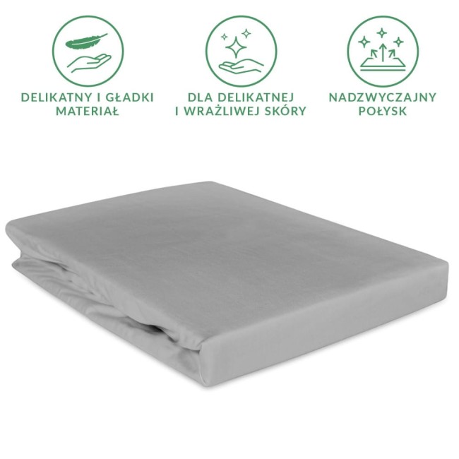 Prześcieradło satynowe z gumką 140x200 w kolorze popielatym, leżące na białym tle. Wykonane z gładkiego materiału, z widoczną gumką na brzegach, zapewniającą dopasowanie do materaca. Idealne dla osób ceniących komfort snu.