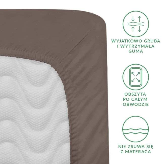 Prześcieradło satynowe z gumką 140x200 w kolorze sepia. Widoczny detal gumy obszytującej po całym obwodzie, zapewniający stabilne dopasowanie. Produkt leży na materiale w fakturze białej, z delikatnym wzorem. Kąt ujęcia: z boku.