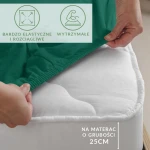 Prześcieradło jersey z elastanem w kolorze zielonym, z gumką. Widoczne ujęcie z boku na leżące prześcieradło zakładające materac o wysokości 25 cm. Na tkaninie widoczne informacje o elastyczności i wytrzymałości, na białym tle materaca.