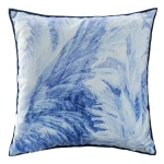 Poszewka dekoracyjna 43x43 cm w odcieniach błękitu, z zimowym wzorem przypominającym śnieżne wiry. Materiał: miękki, teksturowany. Ułożona na płasko, z widoczną granicą wykończoną w ciemniejszym kolorze.