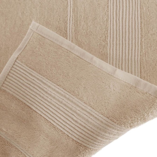 Ręcznik bambusowy 70x140 w kolorze cappuccino, leżący na jasnym tle. Widoczne napisy w formie drobnych, poziomych pasów na jednym z brzegów. Materiał o miękkiej, teksturowanej fakturze. Złożony brzegi z delikatnym obszyciem.