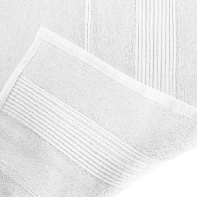 Ręcznik bambusowy 50x90 cm w kolorze białym, leżący na powierzchni. Widoczna struktura tkaniny z delikatnymi przeszyciami na brzegach. Materiał o gładkiej fakturze, idealny do codziennego użytku.