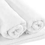 Biały ręcznik hotelowy o wymiarach 70x140 cm, zwinięty w rolkę. Zastosowano miękki i chłonny materiał. Widoczny jest delikatny wzór tekstury. Ręcznik leży na jednolitym tle, co podkreśla jego kolor i fakturę.