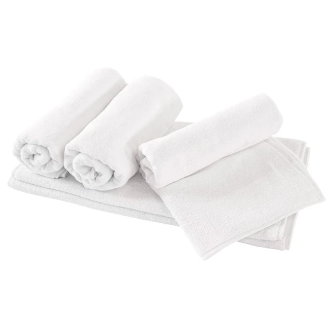 Ręcznik hotelowy 50x100 cm w kolorze białym, leżący na białym tle, obok trzech zwiniętych ręczników. Wykonany z miękkiego materiału, o gładkiej fakturze, z zauważalną w chłodnym oświetleniu, prezentujący prosty design bez wzorów.