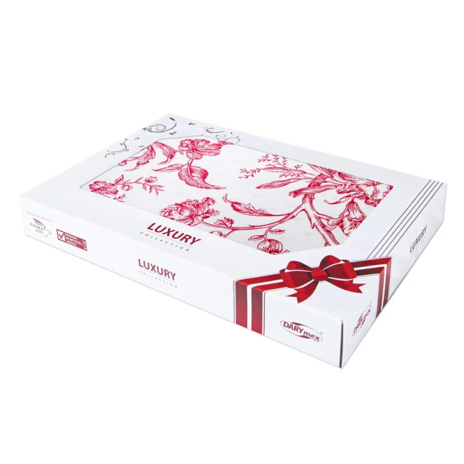 Opakowanie pościeli satynowej 220x200 Luxury Rose Blanc w białym kolorze z czerwonymi kwiatowymi wzorami. Widoczna wstążka dekoracyjna na górze opakowania. Z przodu napis LUXURY COLLECTION oraz logo DARYmex. Położone poziomo na jednolitym tle.