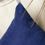 Poszewka dekoracyjna 40x40 w kolorze ciemno niebieskim, gładka, z widoczną teksturą materiału. Ujęcie z boku, ukazujące róg poduszki. Tło jasne, neutralne, co podkreśla kolor poszewki. Brak dodatkowych detali.