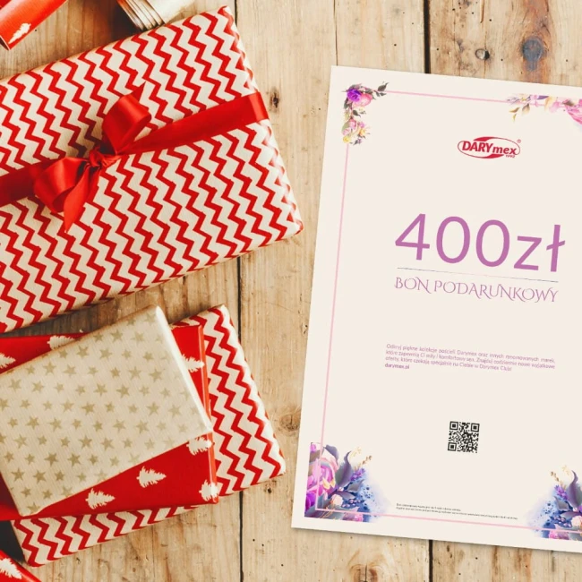 Karta podarunkowa o wartości 400 zł, umieszczona na drewnianym tle, obok kolorowo zapakowanych prezentów. Karta ma jasne tło z różową ramką, widoczny tekst „400 zł” oraz napis „BON PODARUNKOWY”. Obok karty dostrzegalny kod QR.