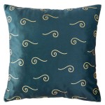 Poszewka dekoracyjna w rozmiarze 40x40 cm, o eleganckim, ciemnozielonym tle z jasnymi, złotymi falami. Produkt leży na płasko, z wyraźnie widocznym wzorem. Materiał ma gładką, błyszczącą teksturę, co podkreśla nowoczesny design.