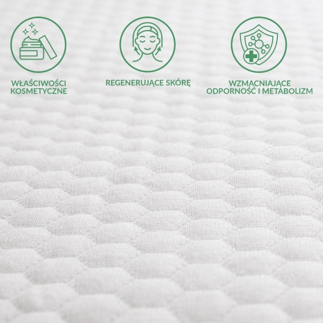 Ochraniacz na materac 160x200 pikowany SOFT-TOUCH w kolorze białym, o fakturze w romby. W widoku z bliska, ukazuje właściwości kosmetyczne oraz regenerujące skórę, z ikonami przedstawiającymi te cechy.