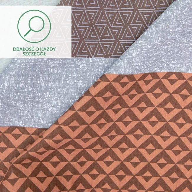 Pościel satyna bawełniana 160x200 Exclusive Mia w pomarańczowo-brązowe pasy. Widoczne różne wzory geometryczne na materiałach. Pozycja leżąca, tło proste. Gładka i teksturowana faktura tkaniny.