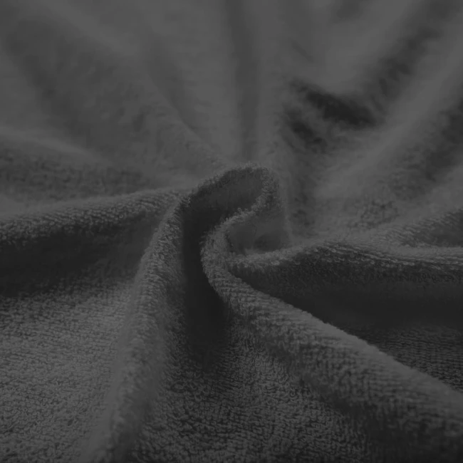 Poszewka frotte 40x40 w kolorze antracyt, z teksturą miękkiego materiału, leżąca na płasko, z widocznymi włóknami. Ujęcie w zbliżeniu na fakturę, pokazujące detale splotu. Tło ciemne, jednolite, co podkreśla kolor poszewki.