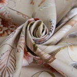 Pościel bawełniana 200x220 Cottonlove Exclusive Sidelya, beżowa, z kolorowymi kwiatami, leżąca w formie złożonego rulonu. Wzory kwiatowe i liściaste, delikatna faktura materiału. Tło proste, bez zakłóceń, co podkreśla szczegóły wzoru.