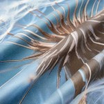 Pościel satynowa 220x200 cm w granatowym kolorze z grafiką dmuchawca, ukazana w złożeniu. Materiał gładki, lekko błyszczący, w pełnym zbliżeniu na detale wzoru. Tło jest jasne, co podkreśla intensywność barw. Brak widocznych napisów lub logo.