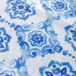 Ścierka kuchenna Ocean Blue w kolorze białym z niebieskim wzorem kwiatowym i spiralnym. Ułożona płasko, zbliżenie na detale wzoru, przedstawiającego różne odcienie niebieskiego. Materiał tekstylny, idealna do użytku kuchennego. Wymiary: 38x60 cm.