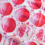 Ścierka kuchenna Tropical Fruits w kolorze białym z dużym, kolorowym wzorem w postaci granatów w odcieniach czerwieni i różu. Ułożona na płasko, ukazuje detale wzoru oraz fakturę materiału. Wymiary 38x60 cm.