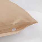 Poszewka satynowa 50x80 w kolorze jasnego beżu, leżąca płasko na jasnym tle. Zamek błyskawiczny w białym kolorze widoczny na krawędzi poszewki, bez wzorów. Gładka faktura materiału, odpowiednia do dekoracji poduszek.